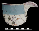 White earthenware jug dipped in blue slip, with painted purple luster floral decoration on both the slipped upper area (fugitive) and the central portion of the jug where the slip has been removed.  Purple luster also painted along beaded rim and spout.